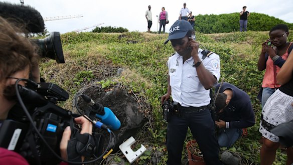 National Police Brigadier Gisele Cadar stands over the plastic object at the site where it was hidden from the media by the man who found it. 