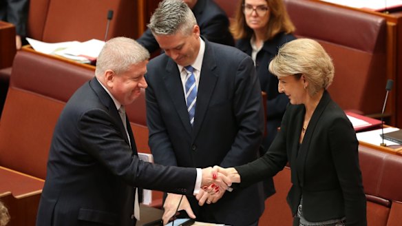 Employment minister Senator Michaelia Cash is congratulated by Communications Minister Mitch Fifield and Finance Minister Senator Mathias Cormann for the passing of the ABCC bill on Wednesday.