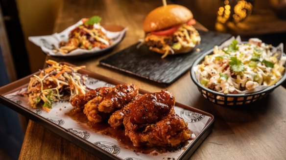 Clockwise from front: Drumettes and wingettes with desi special sauce; crispy Bombay bhel salad; Desi Masala Beef Chopped Cheese Burger; and loaded lamb keema fries at DesiNental.