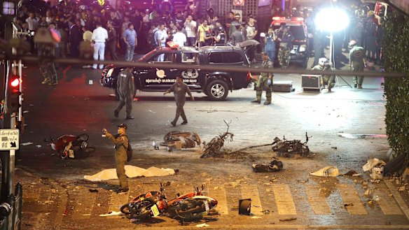 A policeman photographs debris after the August 17 explosion in central Bangkok.