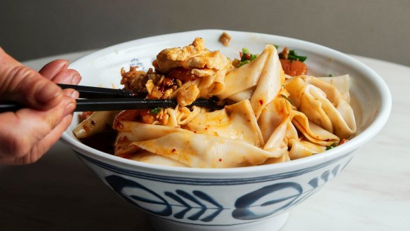 Signature Xi’an biang biang noodles, with egg, tomatoes, potatoes, carrots, pork, shallots, garlic and ginger.