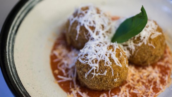 Saffron-tinted arancini with beef ragu and mozzarella.