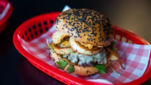 The Wild West burger with a sesame-flecked bun, juicy beef patties, Havarti cheese, grilled onions and crinkle chips.