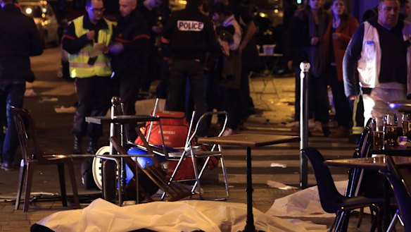 A victim is pictured on the pavement outside a Paris restaurant on Friday.