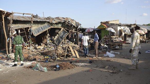 People gather at the site of a suicide bomb attack at a market in Maiduguri, Nigeria in June. Boko Haram is increasingly turning to attacks on gathering places, and struck again on Tuesday night.