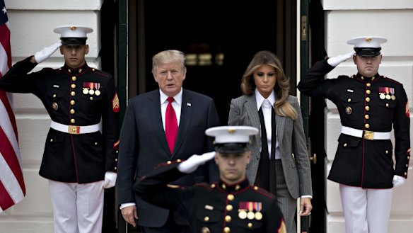The Trumps walk out of the White House to greet guests.
