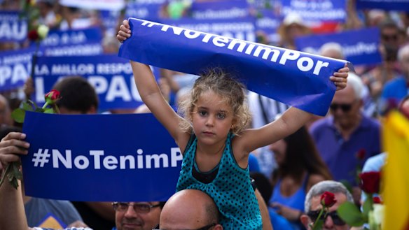 A young girl holds a sign reading "We are not afraid" in the Catalan language during a demonstration condemning the attacks that killed 15 people in Barcelona.