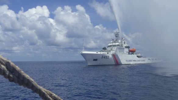 A China Coast Guard vessel approaches Filipino fishermen  off Scarborough Shoal in the South China Sea in September 2015.