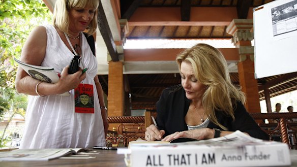 Author Anna Funder autographs her books at the Ubud Writers and Readers Festival in 2012. 