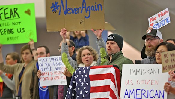 People chant slogans at Indianapolis International Airport on Sunday.