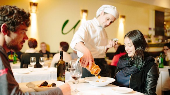 Head chef Fabio Durpetti serves the just-mixed schekerata at a couple's table. 