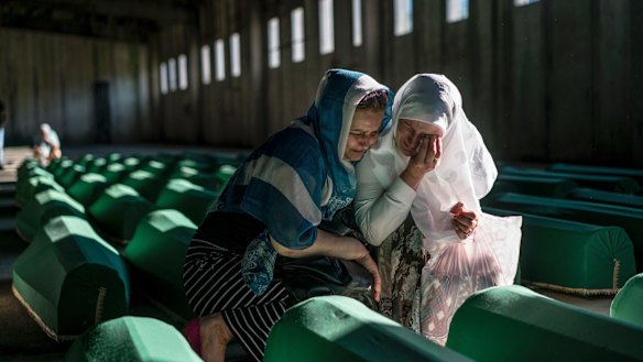 Relatives of people killed in the 1995 Srebrenica massacre mourn over their loved ones' coffins before burial in Potocari, Bosnia, in 2016.