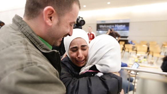 Hisham, left, and Mariam Yasin, centre, welcome their mother Najah al-Shamieh, from Syria, after immigration authorities released her at Dallas-Fort Worth Airport on Saturday.