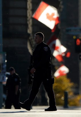 A country shaken: Police continue to patrol a street near the National War Memorial in Ottawa, Ontario.