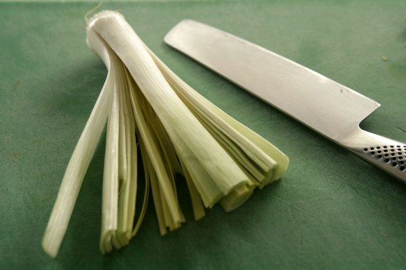 Remove the leek's green part, and slice the length of the whites, leaving the root intact.