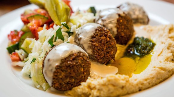 Falafel plate with hummus, tahini and pickles.