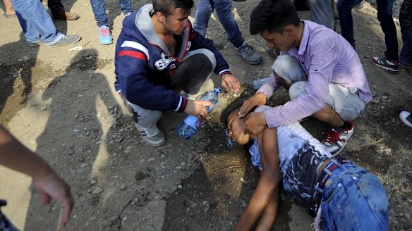 Men help their friend who collapsed.