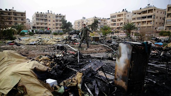 A Russian soldier checks a burnt medical tent after rebels launched a mortar shell at a field hospital in west Aleppo on Monday.