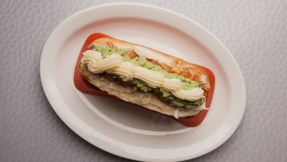 The deluxe dog is topped with tomato, avo, sauerkraut and mayo. 