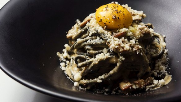 Charcoal bucatini, smoked mushroom pancetta, vegan 'egg' yolk and plant-based parmesan at Mark and Vinny's Spaghetti and Spritz in Sydney.