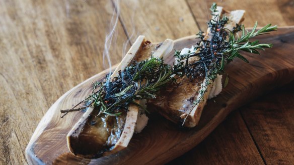Roasted bone marrow is served simply with garden herbs and toast.