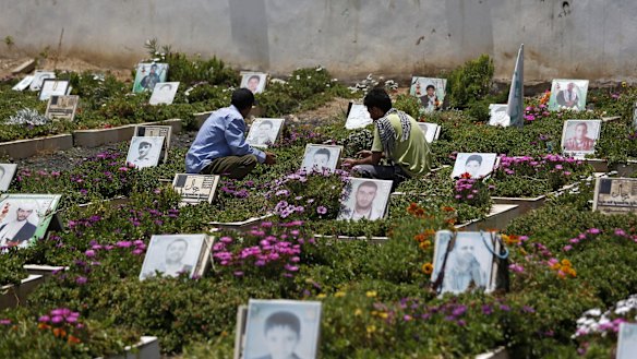 Shiite rebels, known as Houthis, pray at portrait adorned graves of Houthi fighters in Sanaa last week.