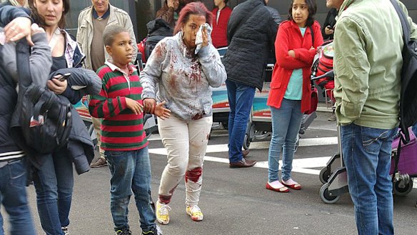 An injured woman leaves the scene at Brussels airport, after explosions rocked the facility on Tuesday.
