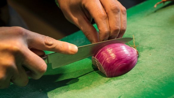 Step 3: Starting on the away side of the onion, slice it from the root end to the top, leaving enough onion connected at the root to hold it together.