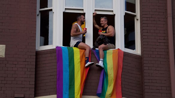 Two men celebrate above a rally on Oxford Street on the night the result was announced to Australia.
