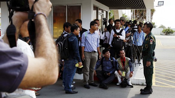 Journalists wait for the transportation of refugees last year from Phnom Penh International Airport to the accommodation Australia arranged for them.
