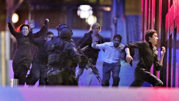 Hostages flee from the Lindt cafe in Martin Place during the early hours of December 16, 2014.