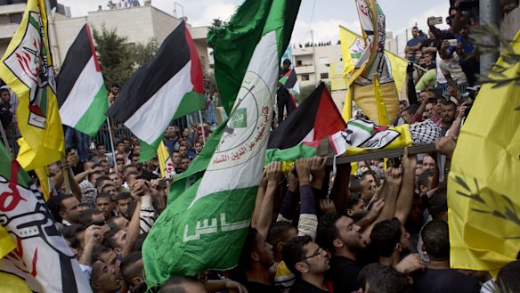 The body of Abdel Rahman Shadi is carried toward the cemetery during his funeral procession at Aida refugee camp, in the occupied West Bank city of Bethlehem.