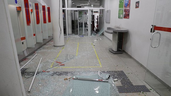 Broken glass is seen inside a bank that was vandalized during a protest against Brazil's President Michel Temer in Sao Paulo.