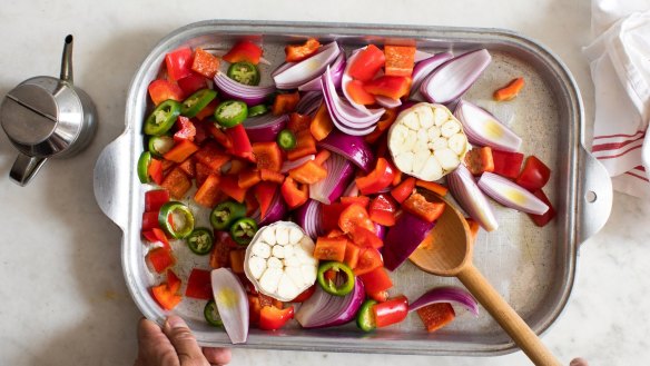 Chopped pieces of onion, red capsicum, jalapeno and garlic ready for roasting.