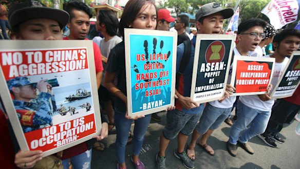 Protesters display placards at a rally near the venue in Manila.