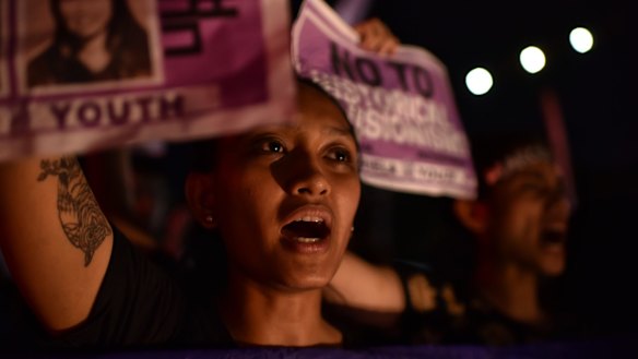 Students and anti-Marcos activists take to the streets of Manila on Friday to protest the hero's burial accorded to him.