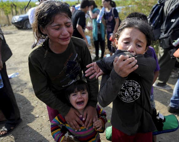 Girls cry as they get separated from their family at the border.
