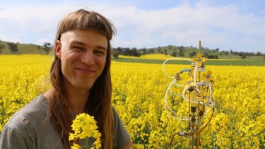 Michael Candy with his "synthetic polleniser” in a canola crop at Shepparton, Victoria, last weekend. The polleniser helps scientists gather data about plants and the bees that pollinate them.