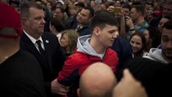 Security guards escort a protester from the start of a campaign event for Donald Trump in Bethpage, New York, on Wednesday.