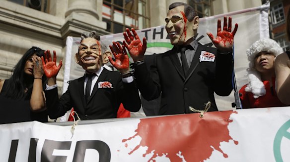 Bloddy hands: Protesters wearing Tony Blair and George W. Bush masks pose in London, shortly before the publication of the Chilcot report.