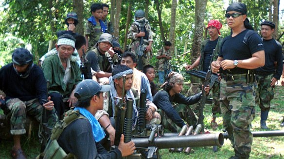 Abu Sayyaf spokesman Abu Sabaya, right foreground, with militants in Basilan, the Philippines. 