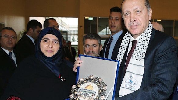 Turkish President Recep Tayyip Erdogan receives a picture of Jerusalem's Dome of the Rock from a Palestinian woman before addressing a symposium on Jerusalem in Istanbul in November.