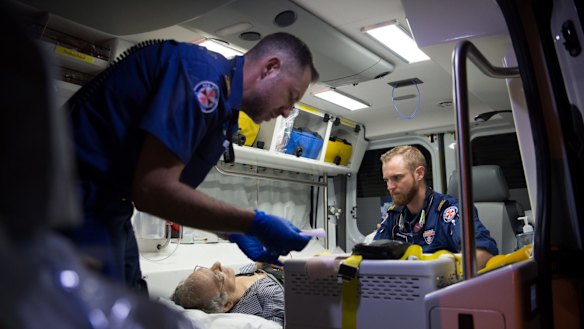 NSW Ambulance paramedics Eugene Roser (left) and Gareth Garne work on a 70-year-old Leichhardt man who experienced loss of consciousness and low blood pressure.