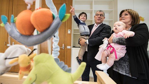 John Ajaka holds his grandson John Urbano, 2, and Speaker Shelley Hancock holds 7 month old Audrey Richards, the daughter of MP Melanie Gibbons in the new parents room.