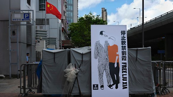 A banner displaying a sketch of late Chinese Nobel Peace laureate Liu Xiaobo and his wife Liu Xia is displayed outside the Chinese liaison office in Hong Kong.