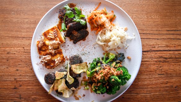 A selection of pick 'n' mix side dishes at Small Graces (pictured clockwise from left: halloumi with walnuts, beef short rib, kimchi, pickles, greens and black pudding).