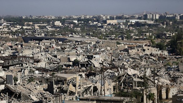 In this July 6 photo, bomb-damaged buildings in Jobar, a rebel-held suburb of Damascus, can be seen in the foreground. Damascus itself can be seen in the distance.  