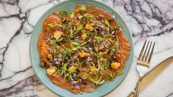 Salmon carpaccio with caper flowers.