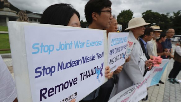 South Korean members of a civic group hold banners during a rally against the South Korea-US Joint military drills outside of the presidential Blue House in Seoul on Monday.