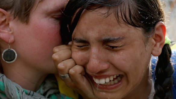 A migrant girl is overcome by pepper spray and tear gas after Hungarian police repelled an attempt by migrants to break the border post gate and pull down the razor wire fence in Horgos, Serbia. 